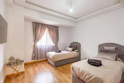 a bedroom with two beds and a window at Appartement moderne 5 min au centre ville in Marrakech