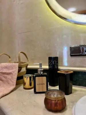a bathroom counter with a bottle of perfume and candles at Bel appartement à Babylone 1 in Marrakech