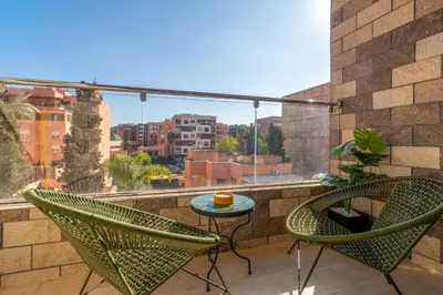 two chairs and a table on a balcony with a view at Urban Escape in Gueliz with Balcony and Wifi in Marrakech