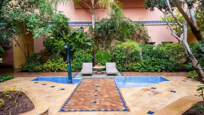 a pool with chairs and a table in a courtyard at Yasmine Majorelle Residence Apartment in Marrakech
