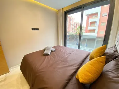 a bedroom with a bed with yellow pillows and a window at Chic & Confort à Marrakech in Marrakech