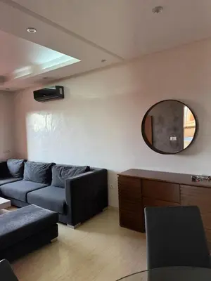 a living room with a couch and a mirror at Appartement de luxe avec piscine et parking gratuit in Marrakech