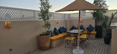 a patio with a table and chairs and an umbrella at Riad Kasbah 82 in Marrakech