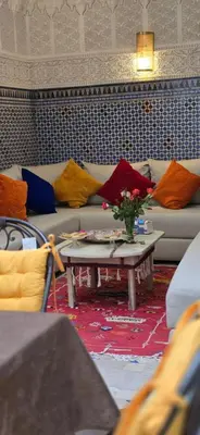 a living room with a couch and a table with a vase of flowers at Riad Kasbah 82 in Marrakech