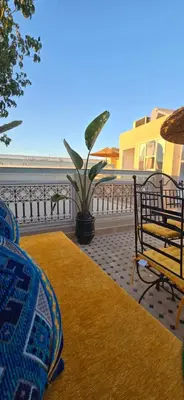a patio with two benches and a rug on a balcony at Riad Kasbah 82 in Marrakech