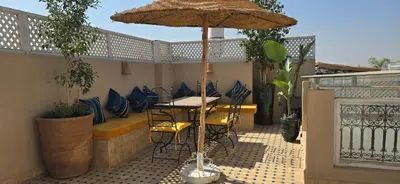 a table and chairs under an umbrella on a patio at Riad Kasbah 82 in Marrakech