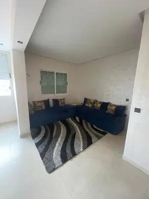 a living room with a blue couch and a rug at Résidence Al Aziziya Near Marrakech Airport in Marrakech