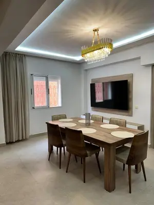a dining room with a table and chairs and a chandelier at Le style a marrakech in Marrakech