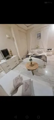 a bedroom with two beds and a table and a tv at Nilia in Marrakech