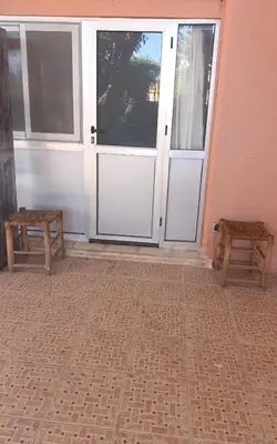 two benches sitting in front of a door at Chambre individuelle studio in Marrakech