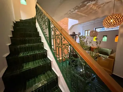 a staircase with green tiles and a wrought iron railing at La Douiria Zaouia in Marrakech