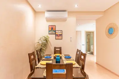 a dining room with a table and chairs at Stylish Flat, Pool, Garden & Fast Wi-Fi in Marrakech