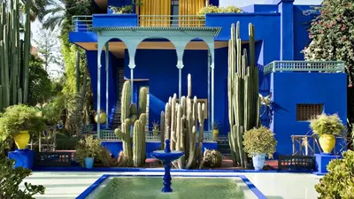a blue building with a fountain and cactuses in front at The Soft Living - Marrakech Centre in Marrakech