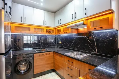 a kitchen with wooden cabinets and a washer and dryer at The Soft Living - Marrakech Centre in Marrakech