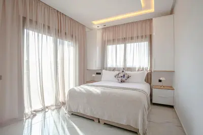 a bedroom with a white bed and large windows at The Blue Harmony - Hivernage Marrakech in Marrakech