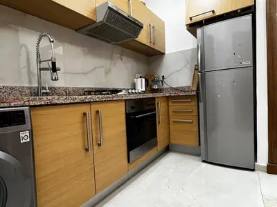 a kitchen with wooden cabinets and a stainless steel refrigerator at Luxurious Traditional & Modern Apartment Guéliz in Marrakech