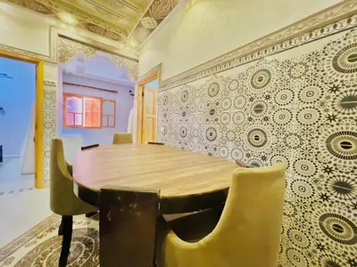 a dining room with a wooden table and chairs at Lovely Family aparts LAGUASSEM in El Gouassem
