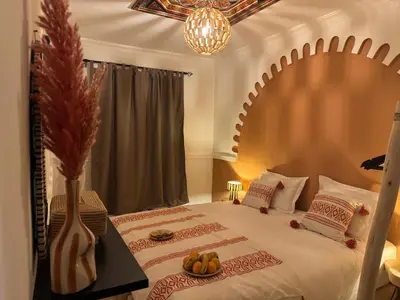a bedroom with a large bed with a bowl of fruit on it at Riad Douha in Marrakech