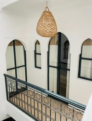 a balcony with black and white walls and windows at Riad Darmoon in Marrakech