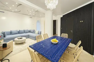 a living room with a blue table with chairs and a couch at Duplex apart with parking by Sabor Voyage in Marrakech