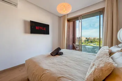 a bedroom with a bed and a window with a view at Comfy Flat 2 BedRooms-Argan Golf Atlas View in Marrakech