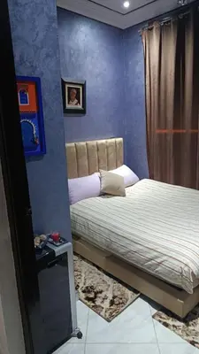 a bedroom with a bed in a room with blue walls at Afaq marrakech in Marrakech