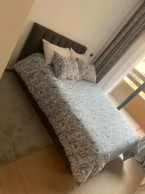 a bed with a blue comforter and pillows in a bedroom at Nour 5 Marrakech Appartement in Marrakech