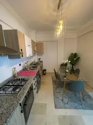 a kitchen with a table and a stove top oven at Nour 5 Marrakech Appartement in Marrakech