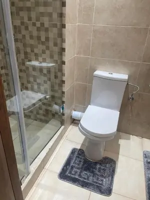 a bathroom with a toilet and a glass shower at Nour 5 Marrakech Appartement in Marrakech