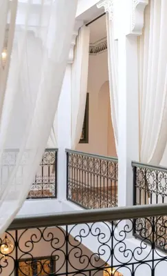 a balcony with white curtains and a window at Riad Sumud in Marrakech