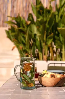 a glass mug on a table with a bowl of fruit at Riad Sumud in Marrakech