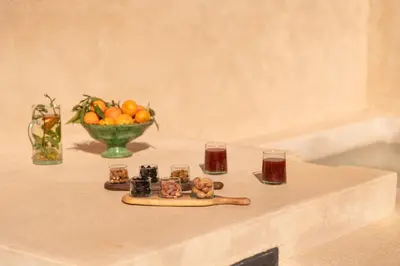 a table with a bowl of oranges and glasses on it at Riad Sumud in Marrakech