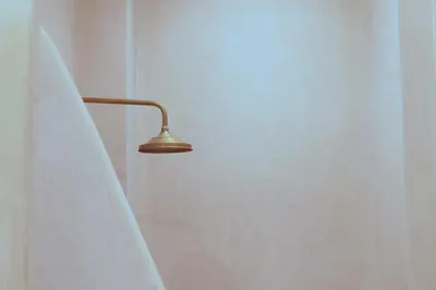 a lamp in a bathroom with a shower curtain at Riad Sumud in Marrakech
