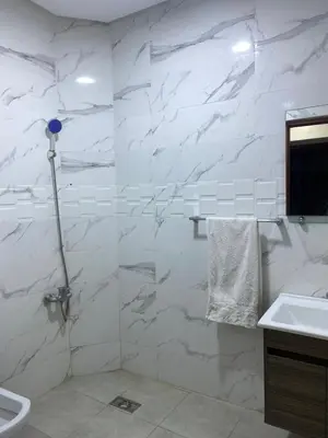 a bathroom with white marble walls and a sink at Majorelle City Apartment in Marrakech