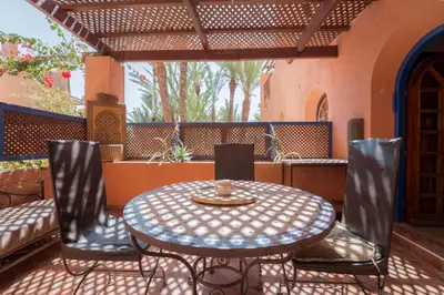 an outdoor table and chairs on a patio at Cozy Quiet Traditional Apartment in Dar Caïd Layadi