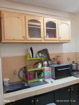 a kitchen with wooden cabinets and a counter top at Appartement familial à Marrakech in Marrakech