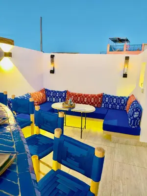 a room with couches and a table and a table and chairs at RIAD El Ma in Marrakech