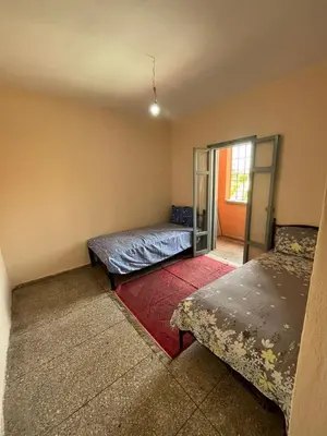 an empty room with two beds and a window at 3Br in heart of Marrakech 15min from downtown in Marrakech