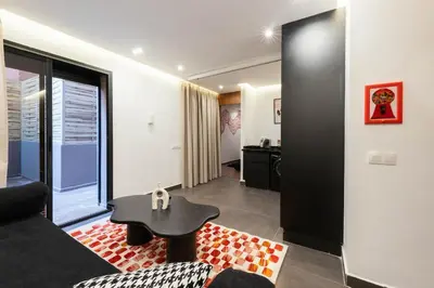 a living room with a black couch and a table at Jacuzzi Private Terrace Design Central Apartment in Marrakech