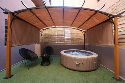 a hot tub in a tent with two chairs at Jacuzzi Private Terrace Design Central Apartment in Marrakech