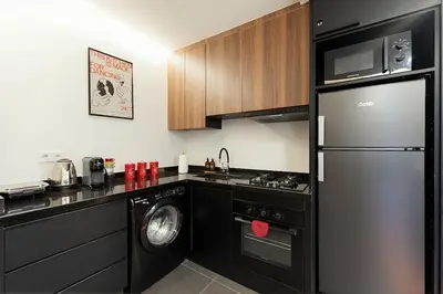 a kitchen with a black refrigerator and a dishwasher at Jacuzzi Private Terrace Design Central Apartment in Marrakech