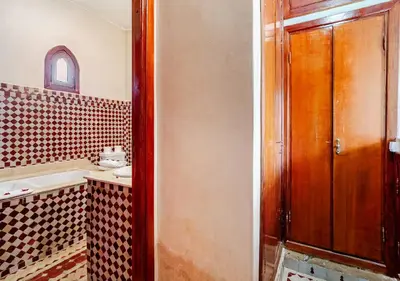 a bathroom with a sink and a wooden door at Private 3 Bedroom Riad Exclusive Use for Families and Friends in Marrakech