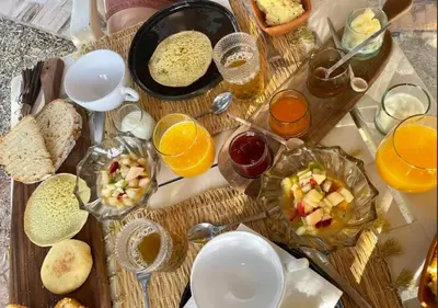 a table with a bunch of breakfast foods and orange juice at Private 3 Bedroom Riad Exclusive Use for Families and Friends in Marrakech