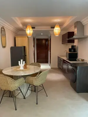 a kitchen and dining room with a table and chairs at Sublime Appartement JACCUZi privé piscine in Marrakech