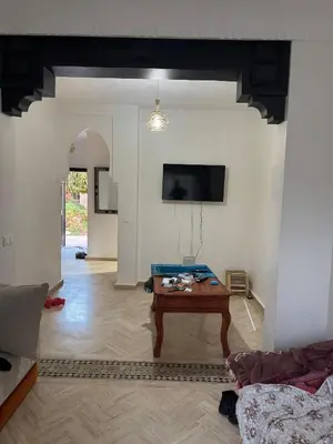 a living room with a table and a tv at Appartement atlas golf ressort in Marrakech