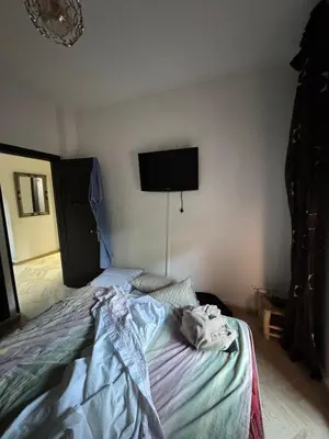a bedroom with a bed with a tv on the wall at Appartement atlas golf ressort in Marrakech