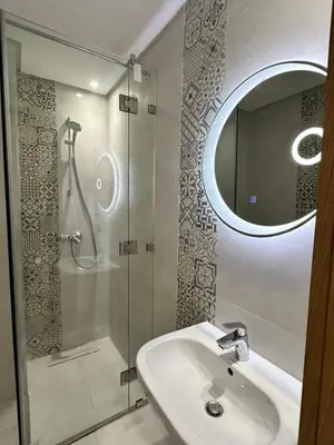 a bathroom with a sink and a shower with a mirror at Marrakech Mood in Marrakech