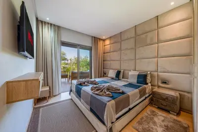 a bedroom with a large bed and a television at Luxury Stay in Prestigia Garden and Pool in Marrakech