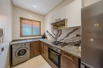 a kitchen with a washer and dryer at Luxury Stay in Prestigia Garden and Pool in Marrakech