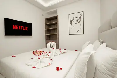 a bedroom with a white bed with flowers on it at Studio au cœur de Guéliz à 5 min de Jemaa el-Fna in Marrakech